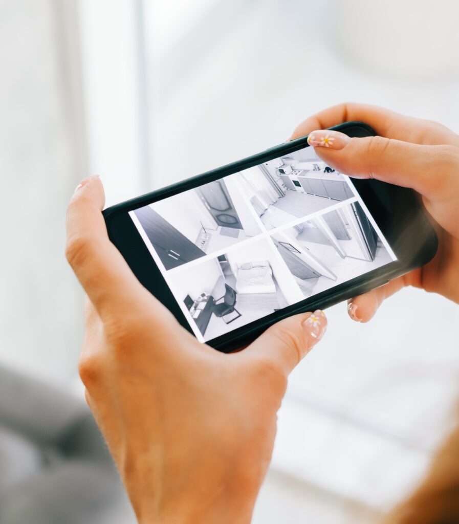 Caucasian woman monitoring security cameras on smartphone indoors, closeup.